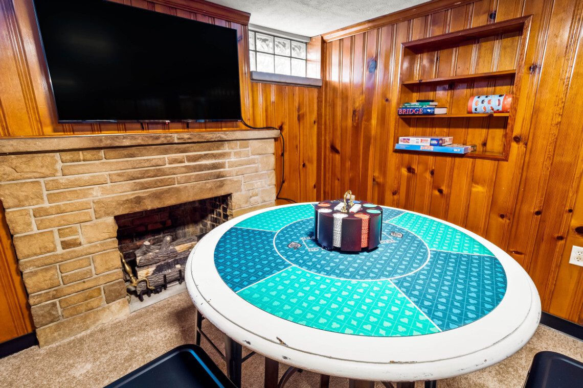 Game room with fireplace, TV, poker table, and lounge area for friends