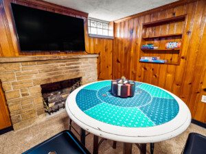 Game room with fireplace, TV, poker table, and lounge area for friends