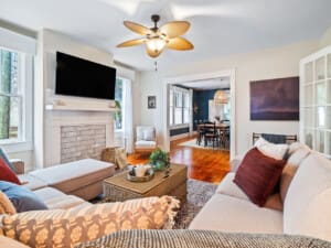 Spacious living room with stylish furniture, ample seating, and a large flatscreen TV for group relaxation and entertainment.