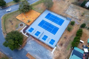 A modern home with a private pickleball court in the backyard, perfect for recreation and relaxation.