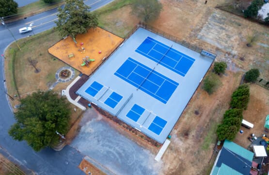 A modern home with a private pickleball court in the backyard, perfect for recreation and relaxation.