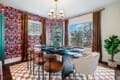 Bright dining room with colorful wallpaper, checkered rug, and stylish table and chairs in a Northeast Ohio vacation rental