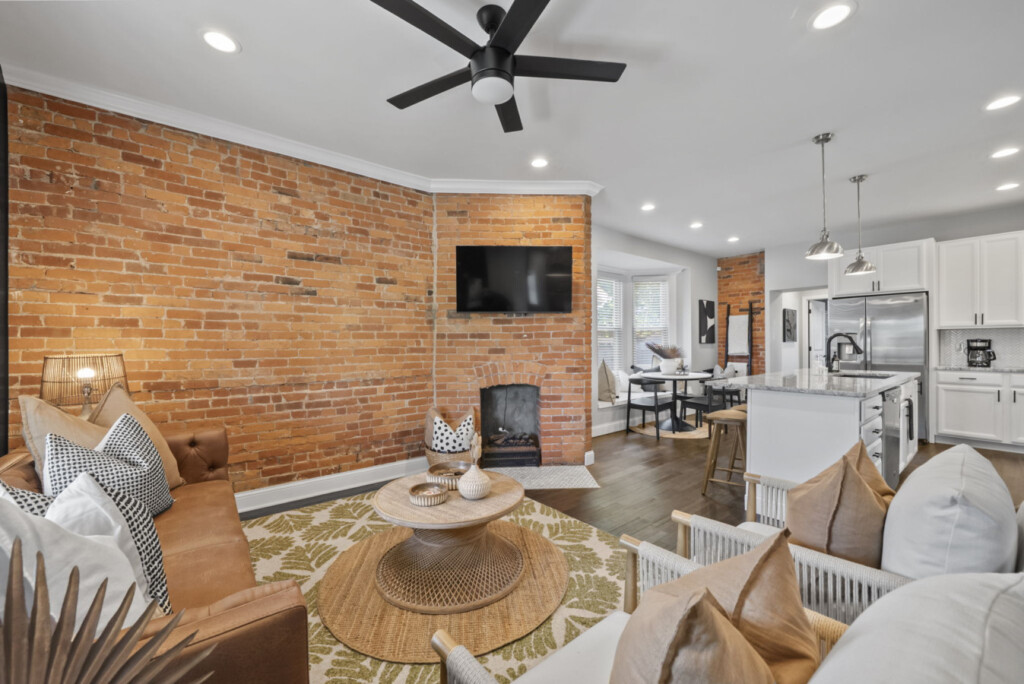 Beautiful living room with brick accent wall, modern décor, and cozy seating for guests