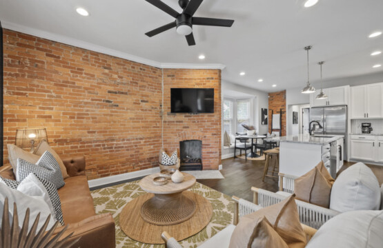 Beautiful living room with brick accent wall, modern décor, and cozy seating for guests