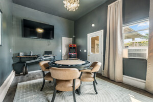 Fun game room with poker table, TV, and retro arcade game in a cozy Northeast Ohio vacation rental.