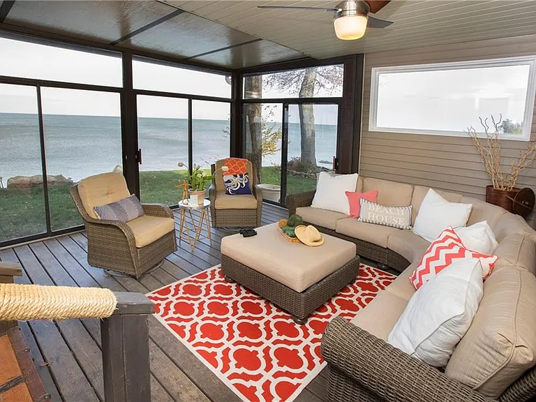 Sunroom with panoramic windows overlooking Lake Erie at a cozy Northeast Ohio vacation home.