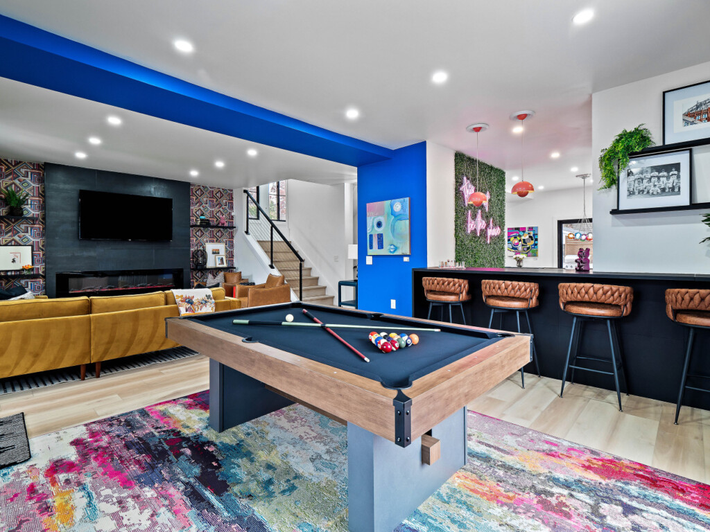 Open-concept living room and game room with pool table and TV in a short-term rental