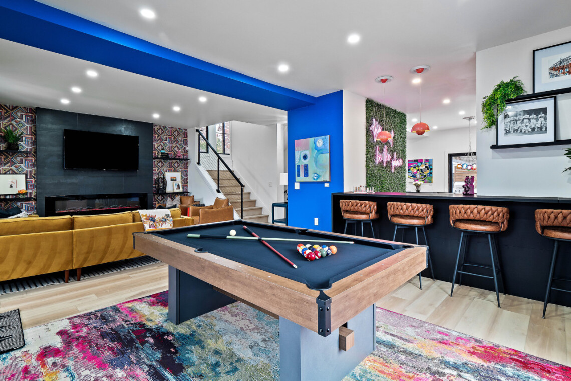 Open-concept living room and game room with pool table and TV in a short-term rental