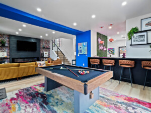 Open-concept living room and game room with pool table and TV in a short-term rental
