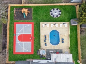 luxury short-term rental backyard with pickleball court, basketball court, firepit, hot tub and playground