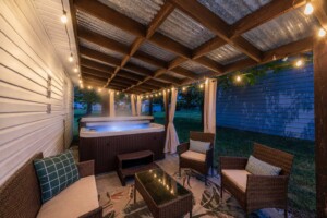 luxury backyard oasis with hot tub and nighttime string lights at a vacation rental home