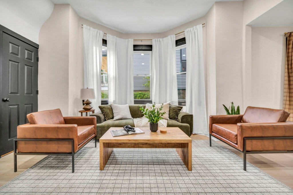 Beautifully designed modern living room with balanced décor, abundant natural lighting, comfortable seating, and inviting gathering space for vacation rental guests
